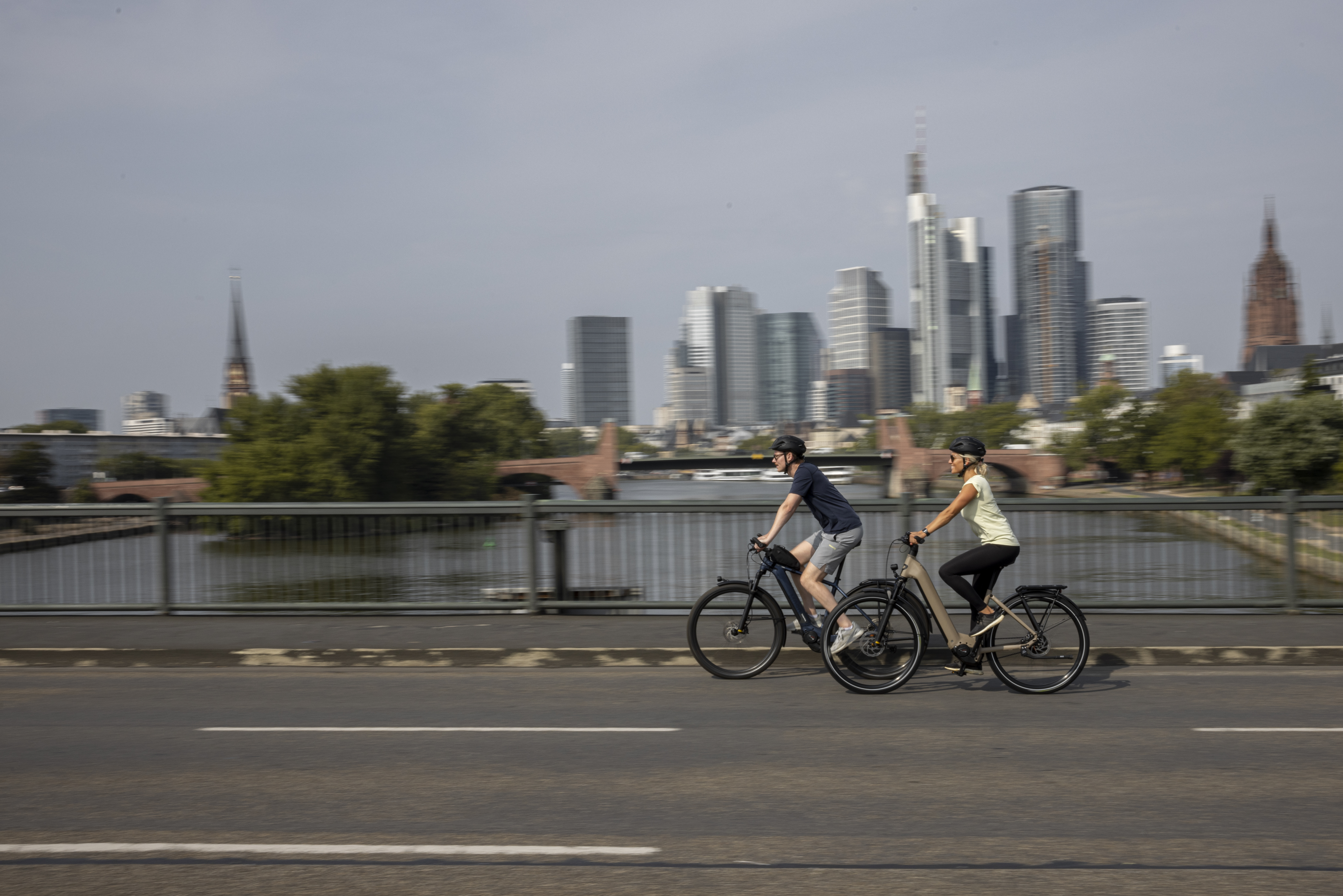 Frau und Mann fahren mit E-Bikes durch die Stadt