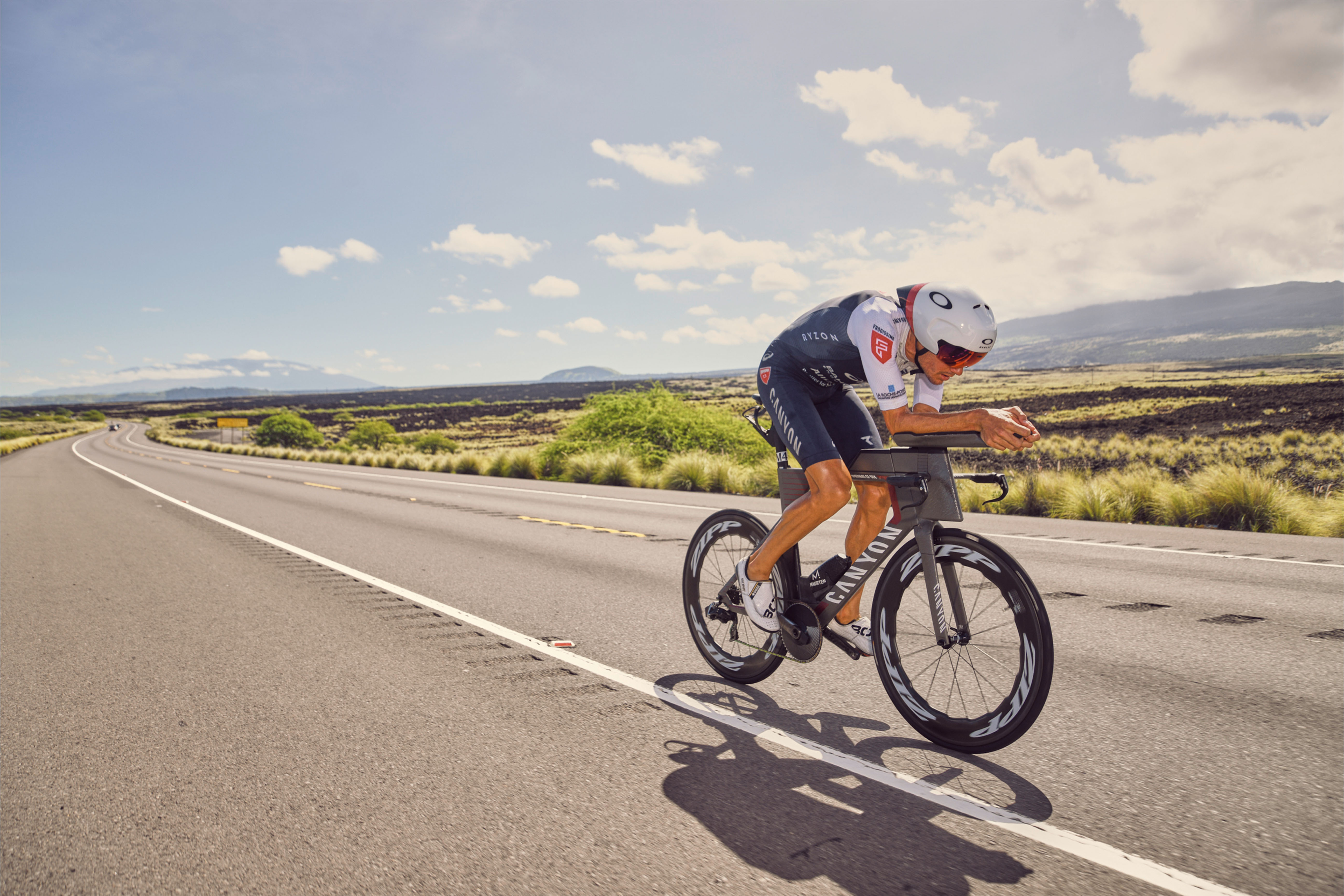 Jan Frodeno färt auf einer Straße durch eine weite Steppe auf seinem Ergon SR Tri in seiner Power Position auf seinem Triathlonrad. 