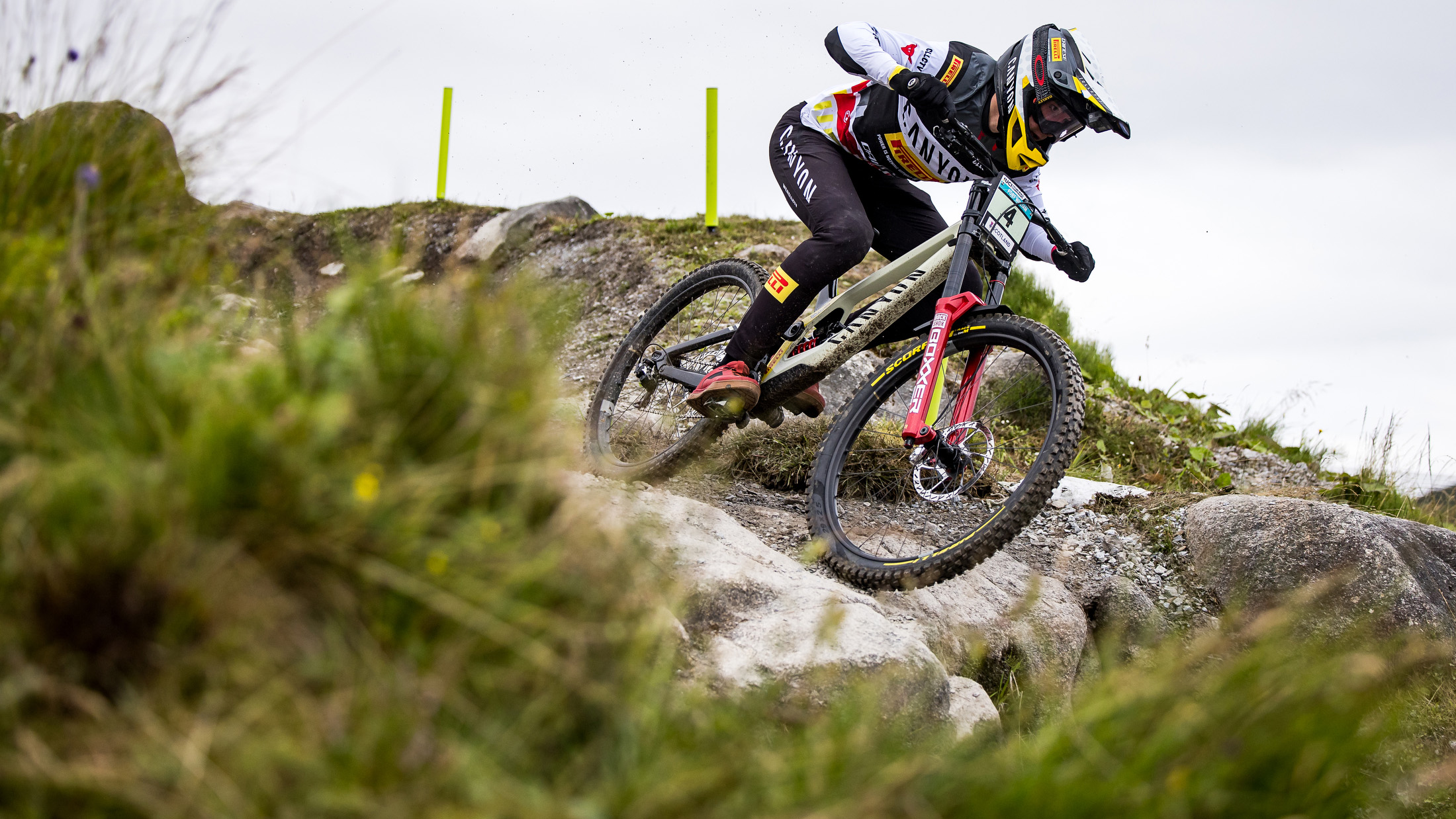 Henri Kiefer jagt mit hoher Geschwindigkeit über felsiges Terrain während eines Downhill-Rennens. Der Ergon Fahrer nutzt seine ganze Technik und Präzision, um die Linie perfekt zu halten.