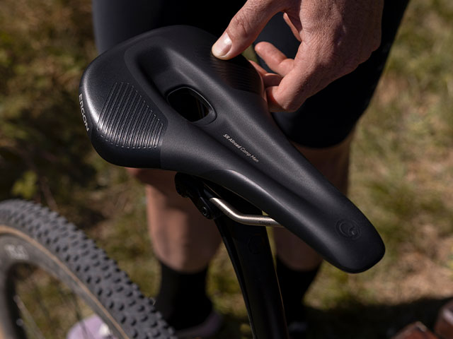 Nahaufnahme des Ergon SR Allroad Pro Carbon Men Sattels, mit Daumen auf dem Sattel, zur Demonstration des Paddings des Sattels.