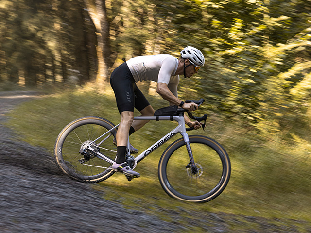 Gravelbiker auf Schotterpiste im Wald auf seinem SR Allroad Pro Carbon Men Fahrradsattel von Ergon.