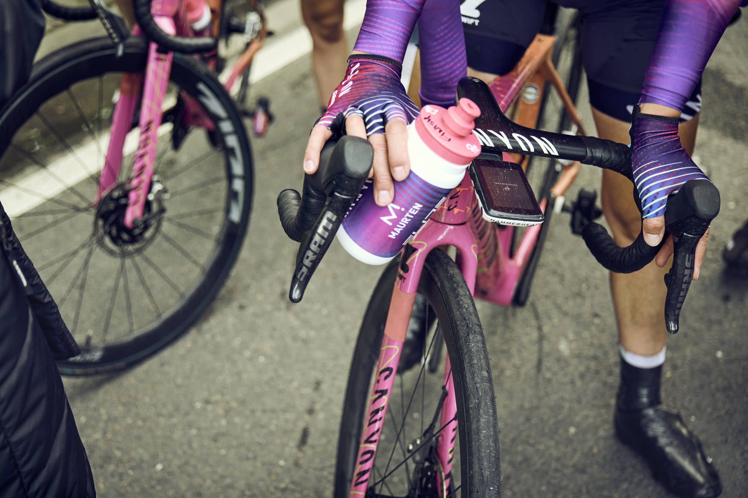 Nahaufnahme von Canyon SRAM Radfahrerhänden am Lenker, Wasserflasche haltend.