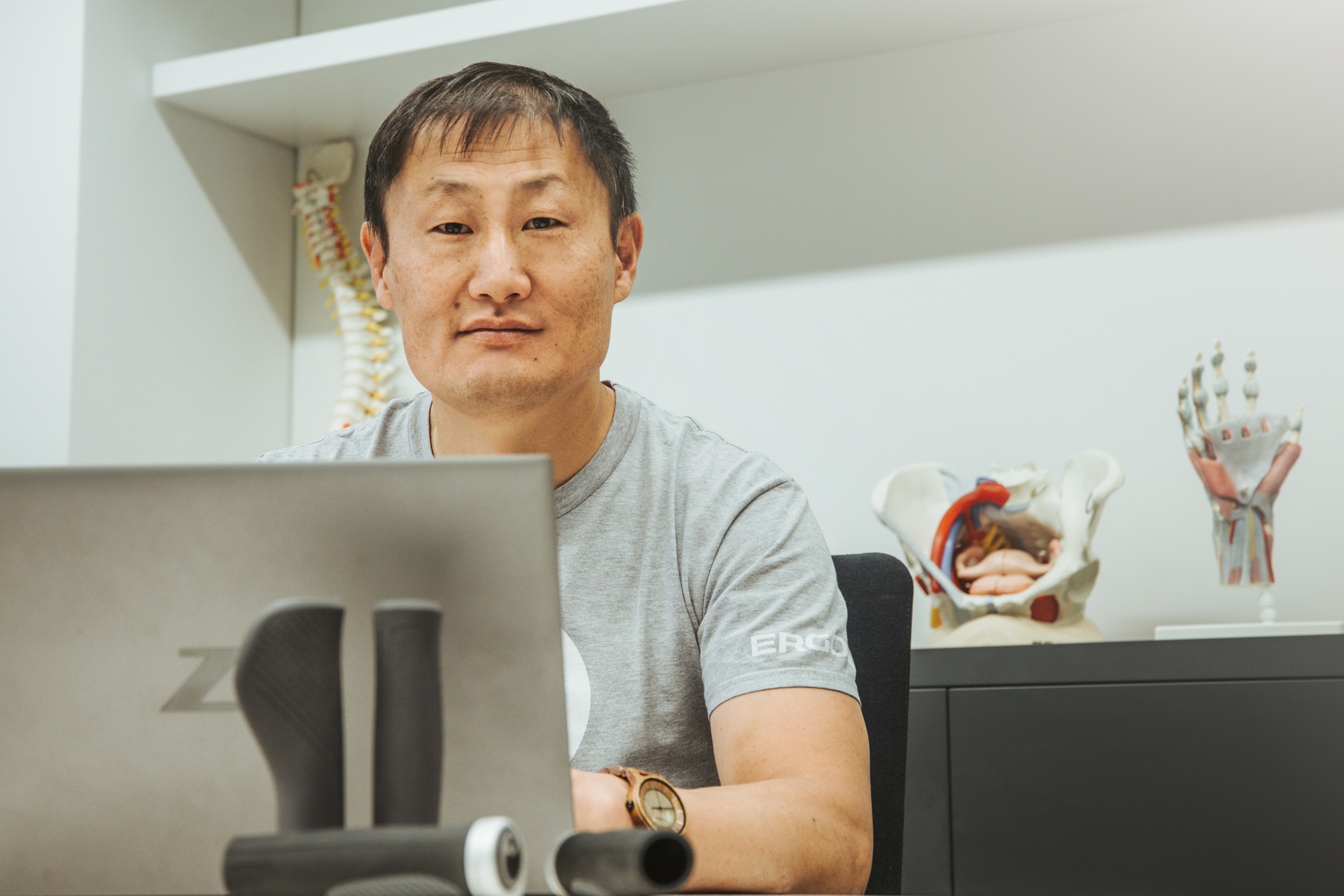Dr. Kim Tofaute am Schreibtisch mit Laptop und Ergon GP1-Griffen im Vordergrund.