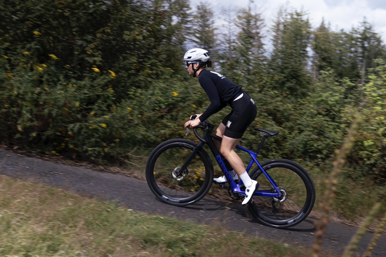 Woman riding a gravel bike on a forest trail