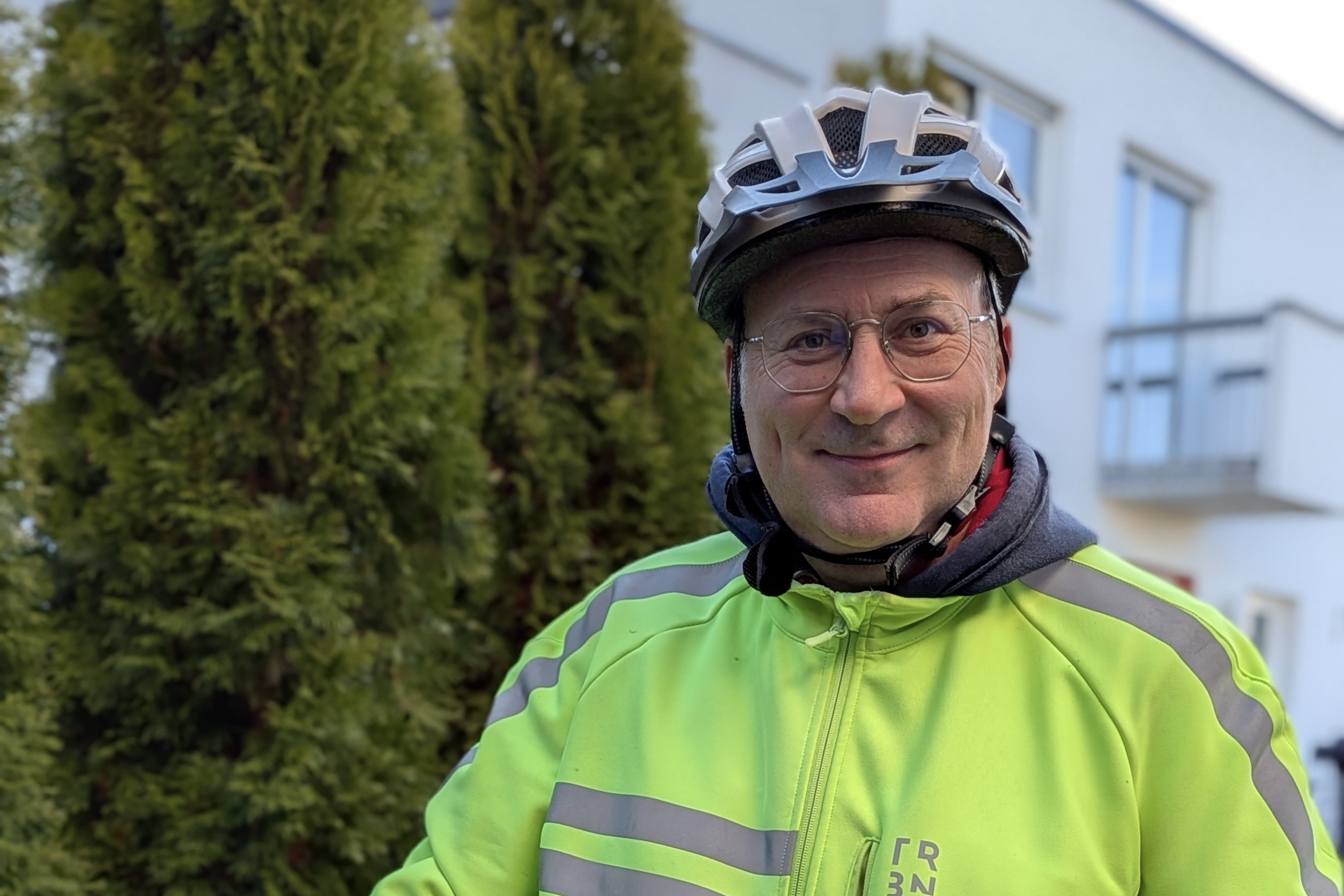 Porträt von Jochen Schniepp, der mit seinem Fahrrad samt montierter GP1 Evo Griffe und einer geleben Warnweste seine Zufriedenheit zeigt.