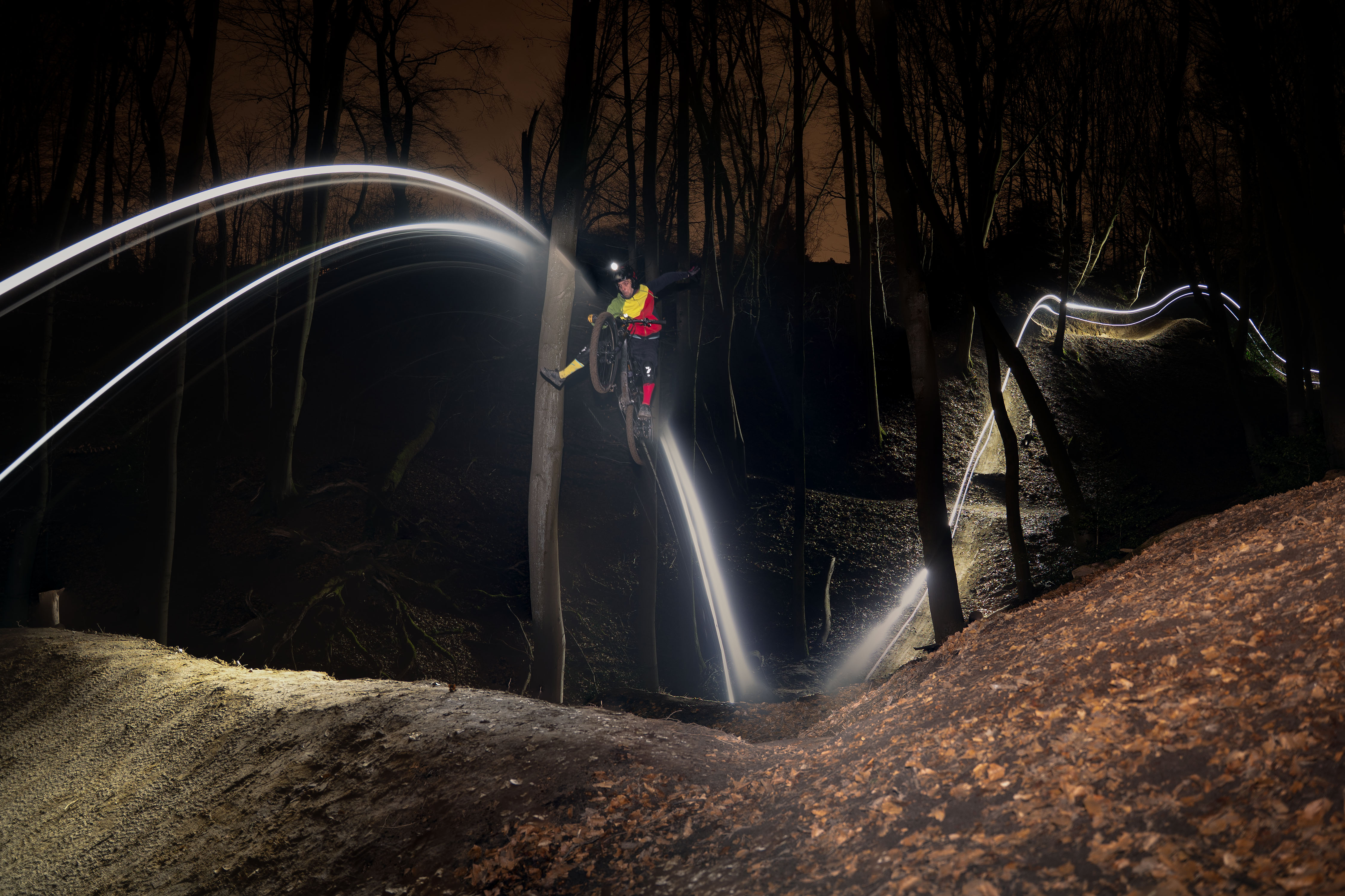 Freeride Mountainbike Nachtaufnahme im Wald – Trail mit Lichtspuren