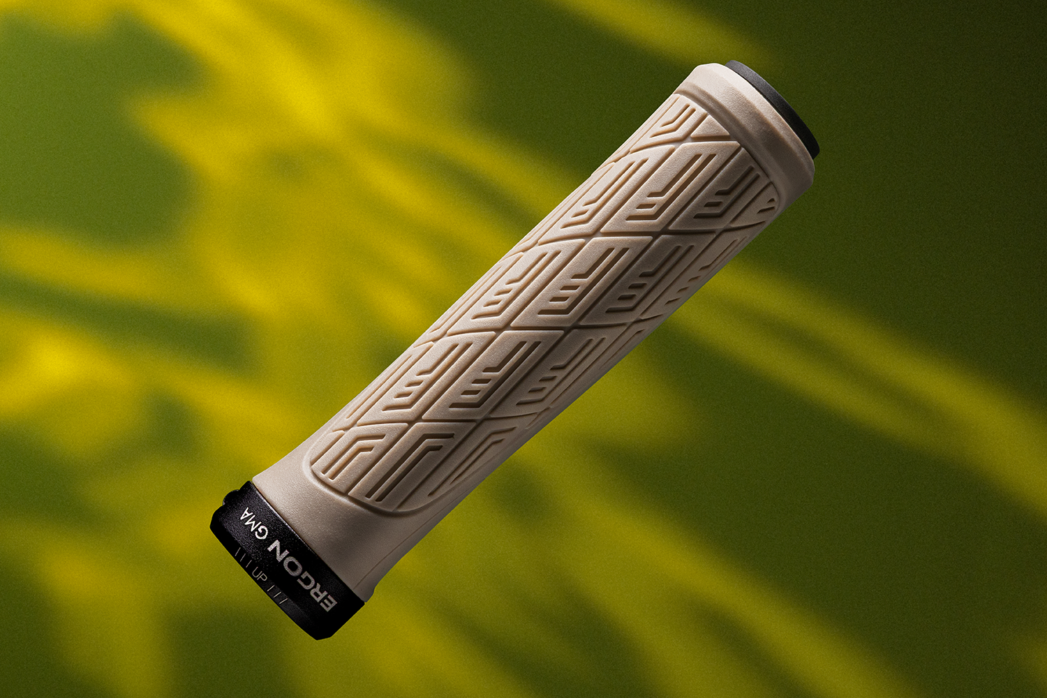 Ergon GMA Mountainbike-Griff in Sandbeige, diagonale Nahaufnahme vor grünem Hintergrund