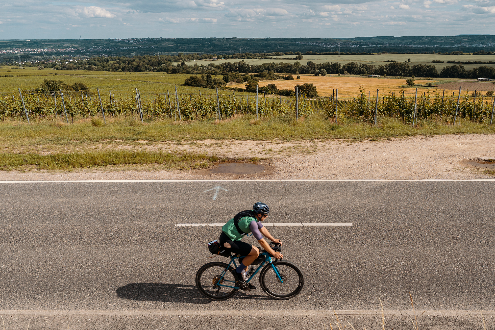 Cyclist rides along a road through wide, open farmland
Photographer Jakab Rokob