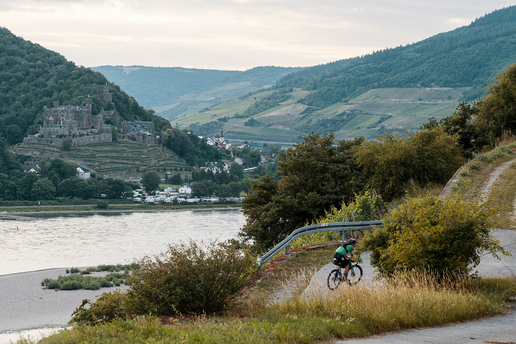 Aerial view of a river valley with vineyards, a cyclist riding along the road below
Photographer Jakab Rokob