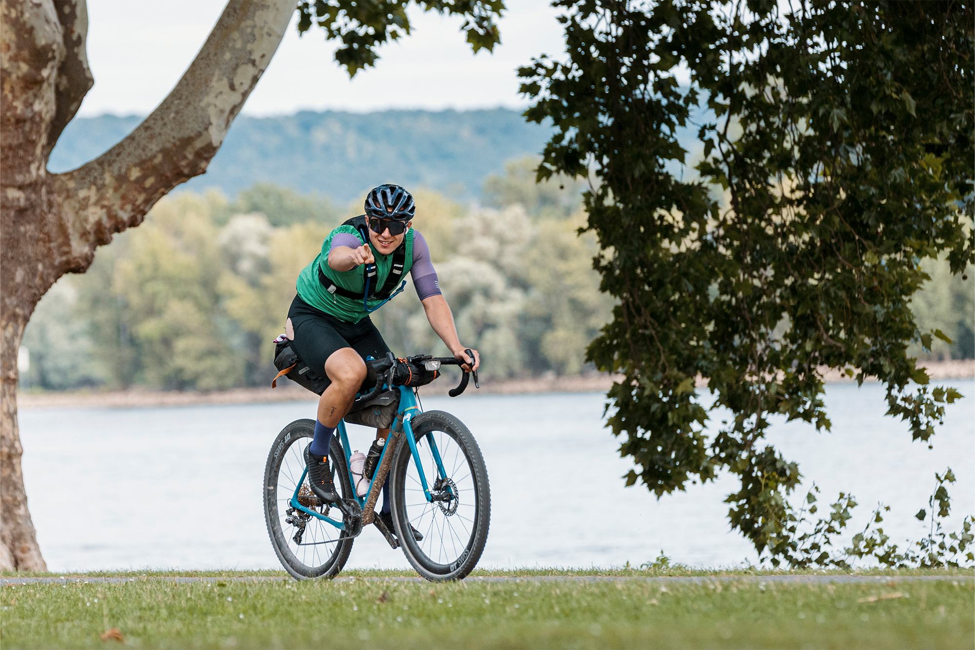 Cyclist rides along a riverside path beneath trees with the river in the background
Photographer: Ingvar Vollprecht