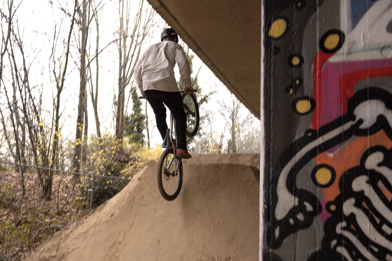 Enduro-Fahrer fährt mit dem Fahrrad eine Rampe in einem Dirtpark hoch