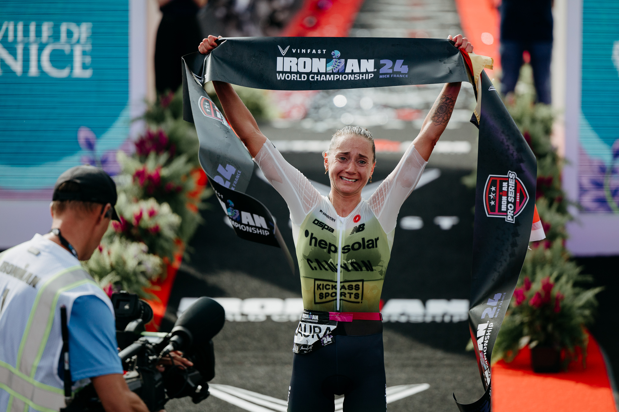 Laura Philipp is emotionally touched after crossing the finish line. She holds the winner's banderole over her head.