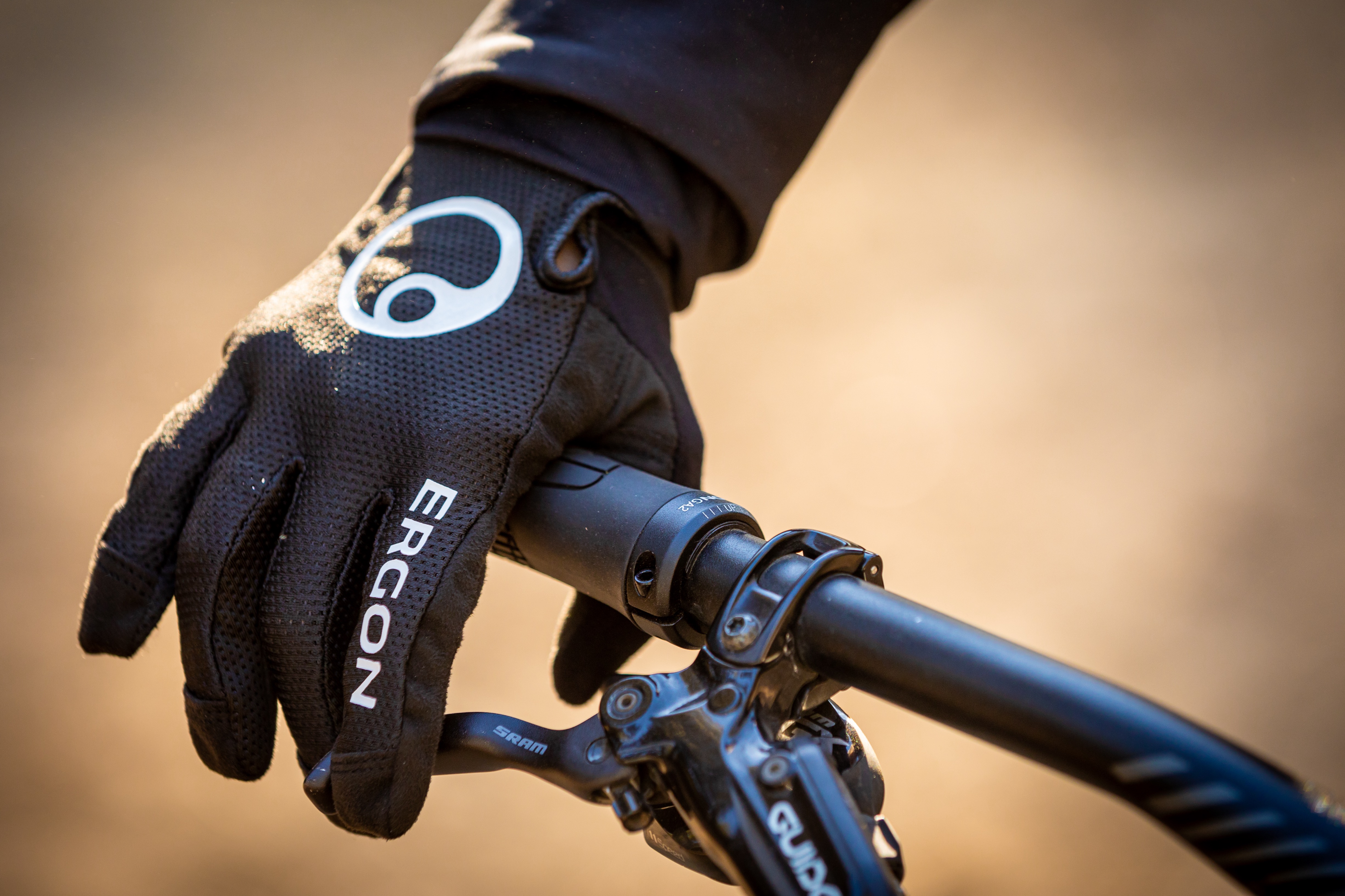 Hand mit Allround-MTB-Handschuh HM2 umschließt Ergon Fahrradgriff. 