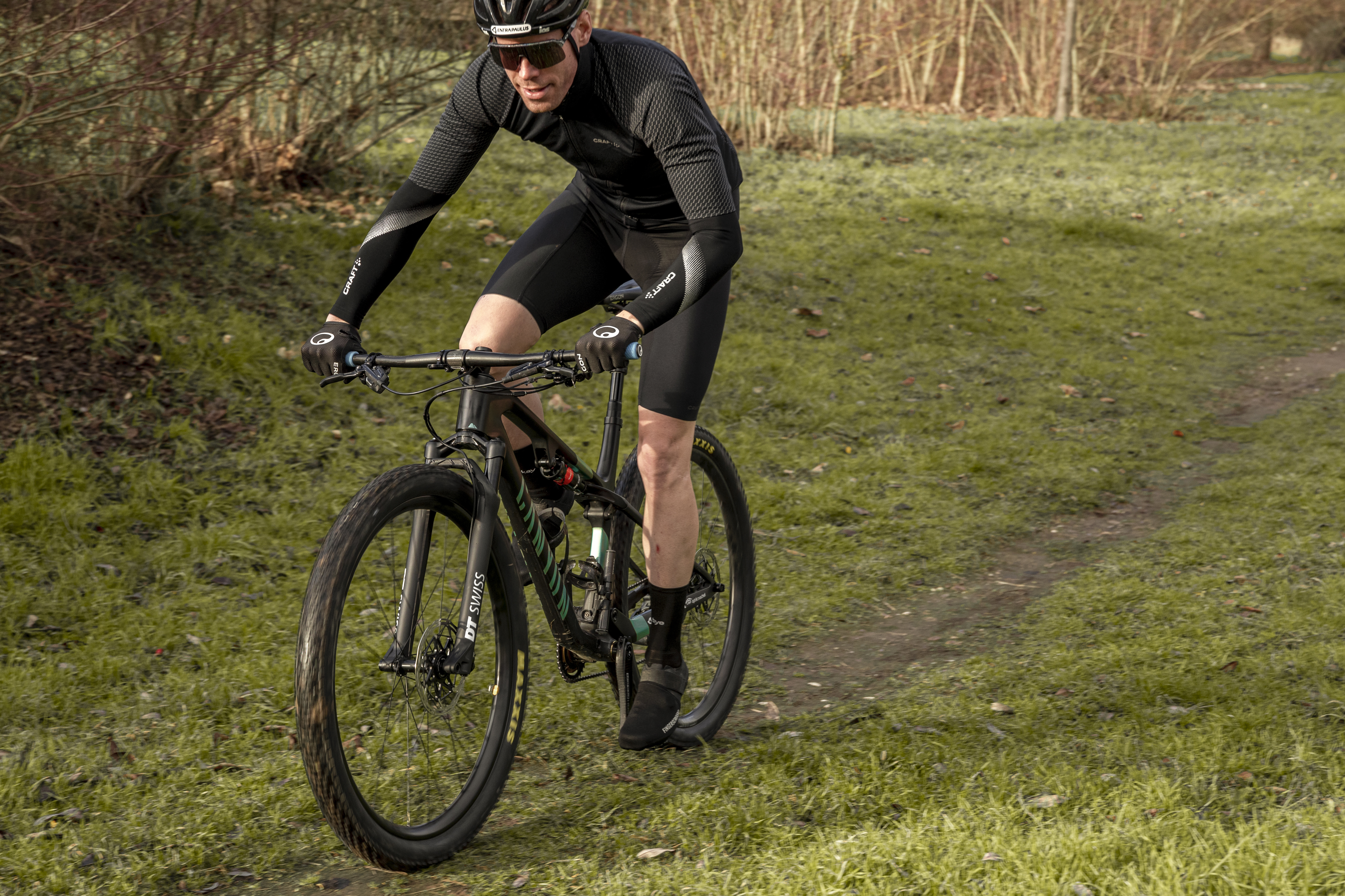 Mann fährt mit dem MTB einen Waldweg entlang.