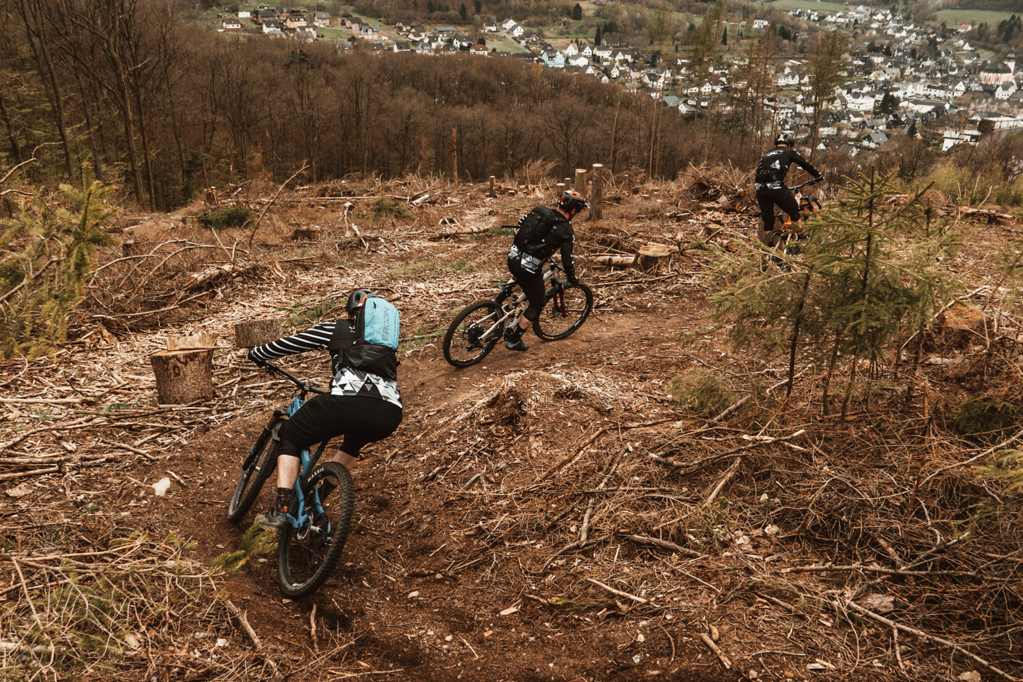 3 MTB Fahrer fahren einen Trail hinunter