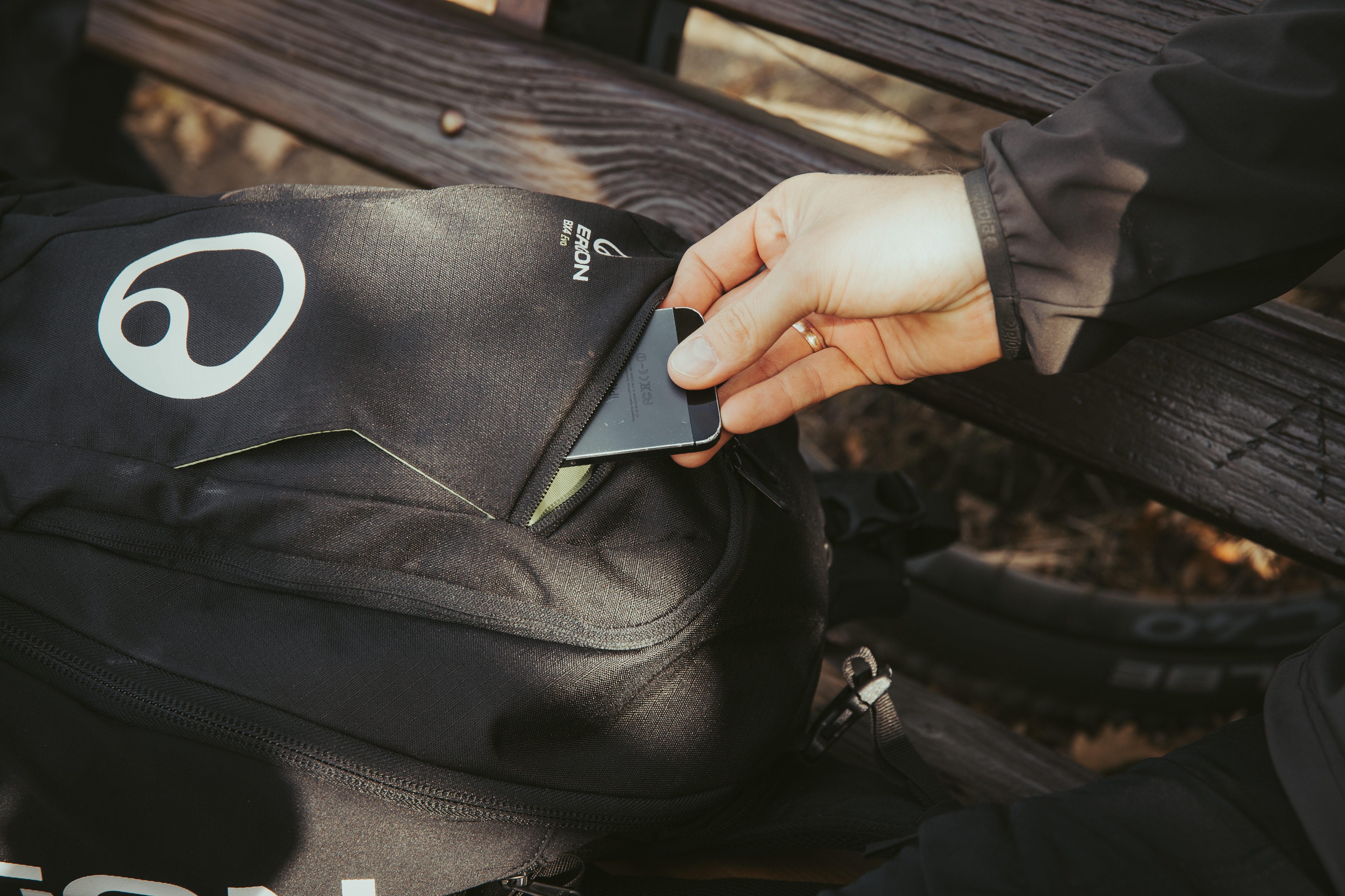 Jemand nimmt ein Smartphone aus dem BX4 Rucksack