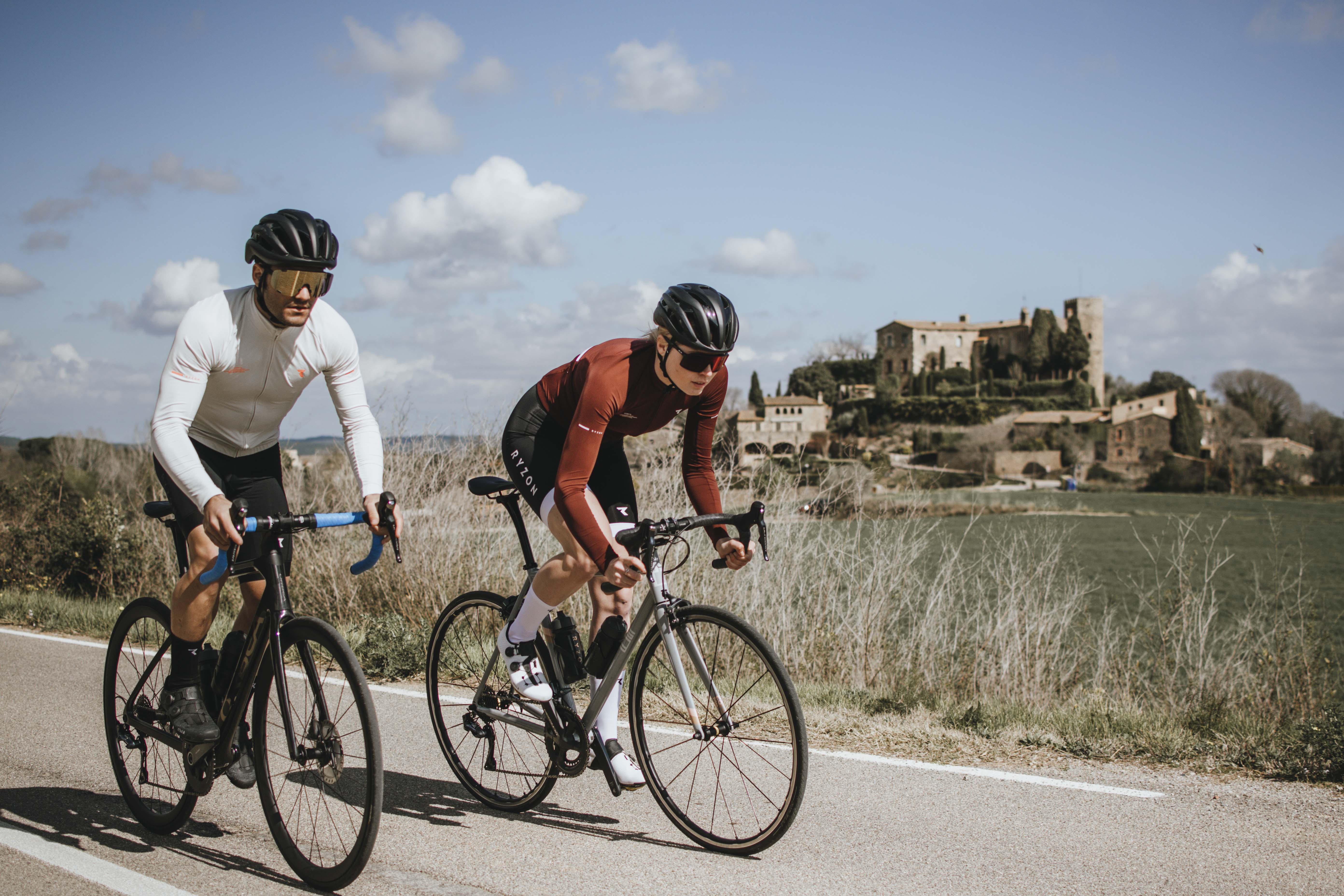 Road Frau Mann Frau und Mann fahren mit Rennrädern auf einer Landstraße.