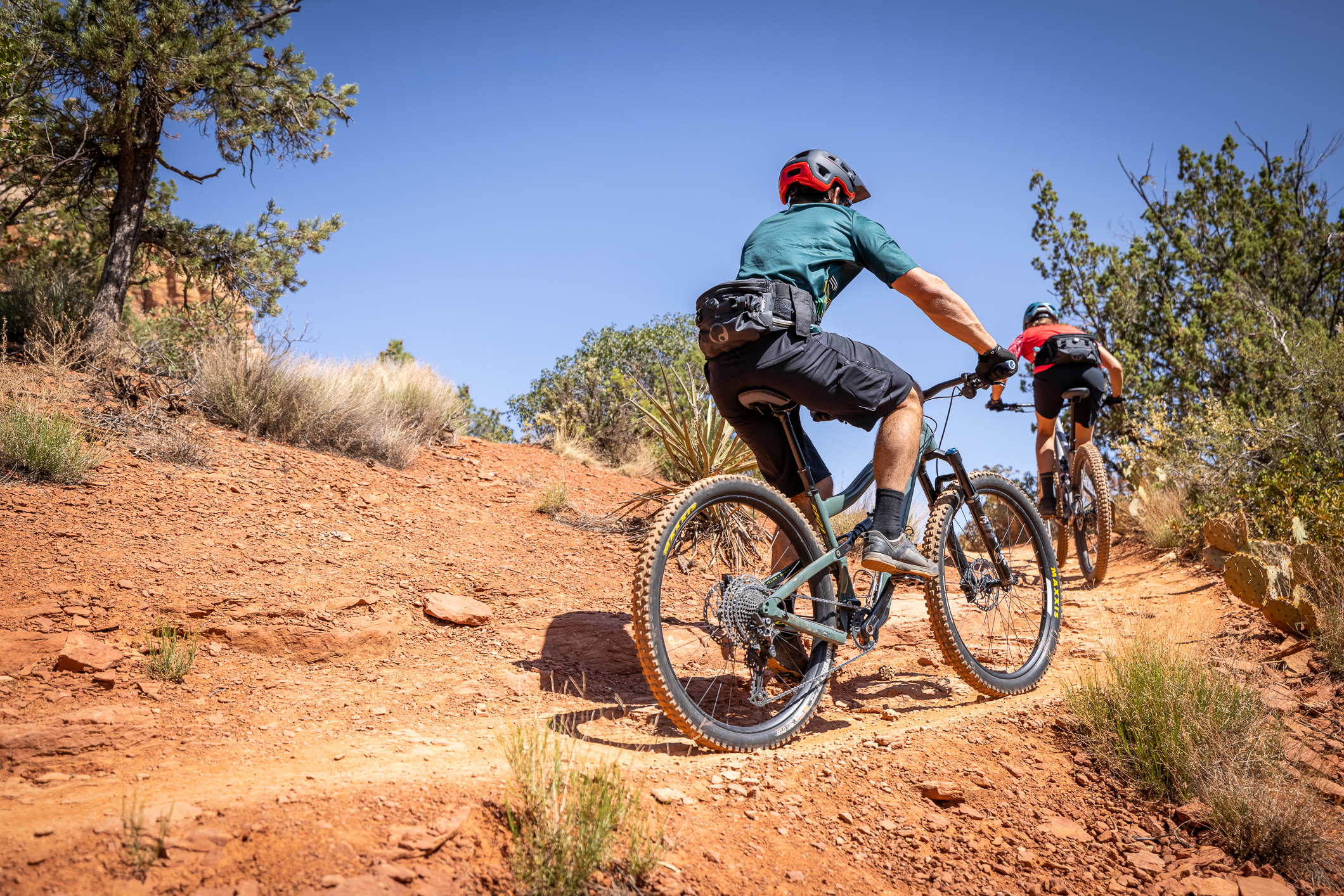 Woman and man riding their mountain bikes through terrain