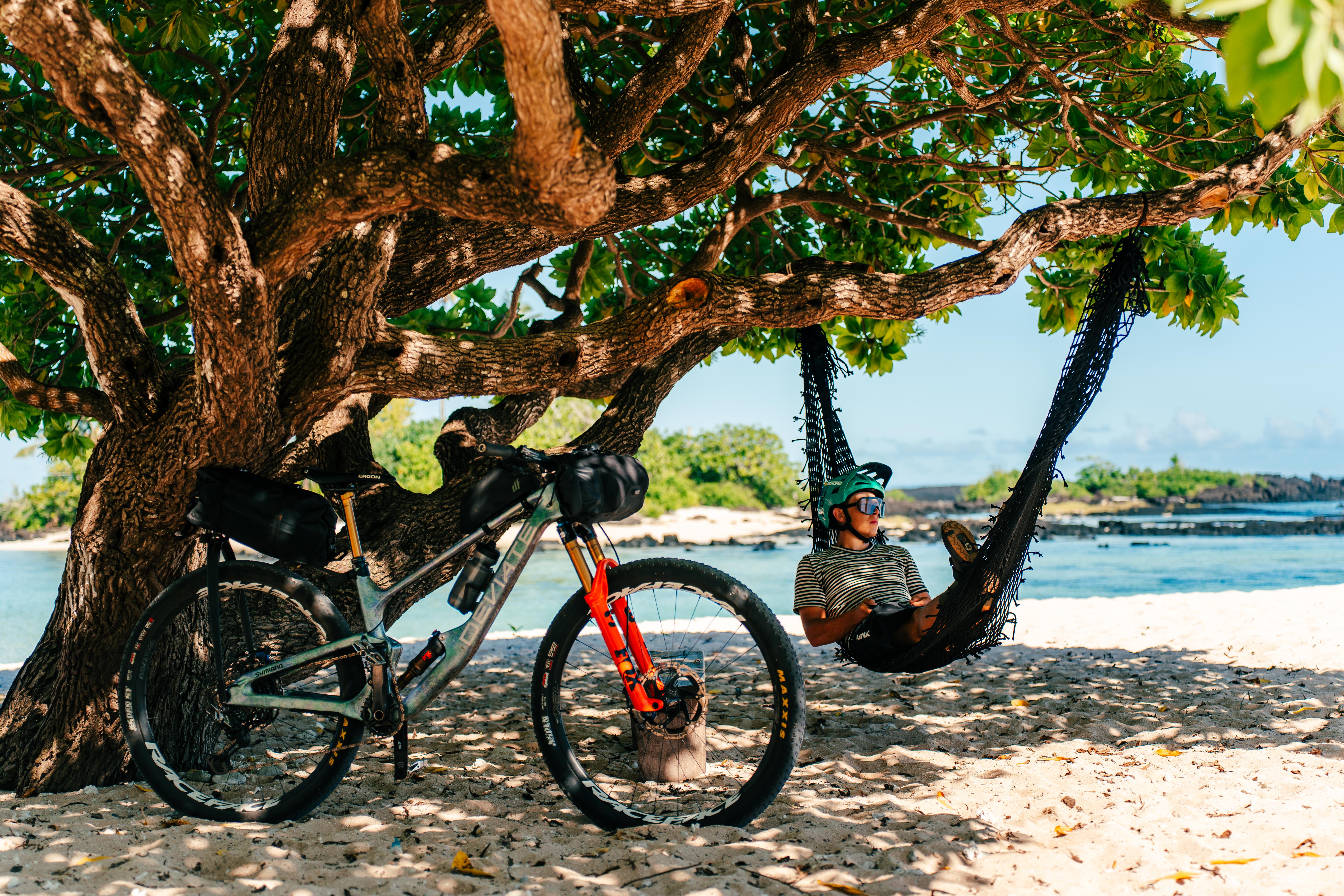 Matthew Fairbrother macht eine Pause in einer Hängematte. Das Bike ist an einen Baum gelehnt.