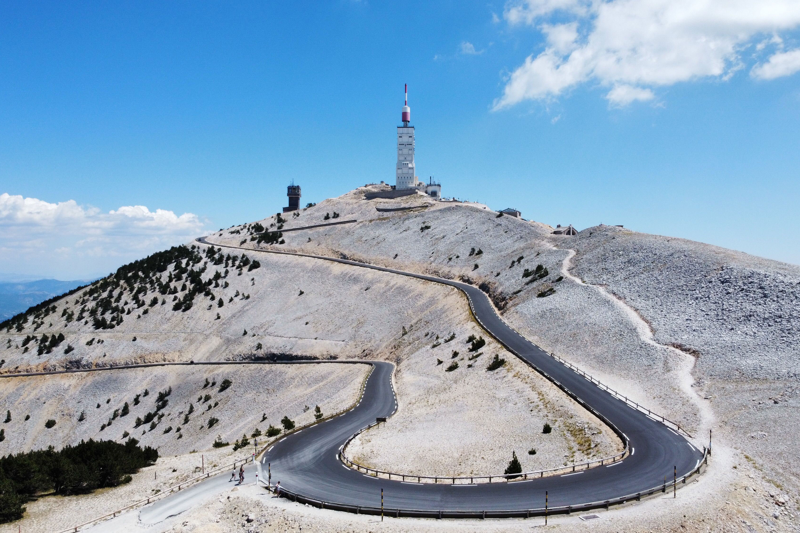 Schmale Autobahn, die zum Mont Ventoux in Frankreich führt, mit blauem Himmel im Hintergrund.
