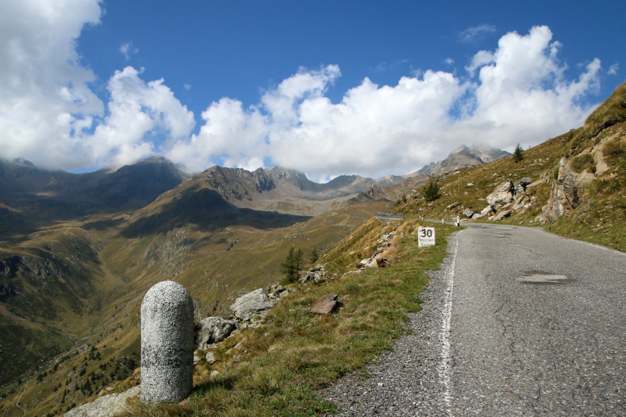 Schneebedeckte Straße des Passo di Gavia mit dramatischer Alpenkulisse.