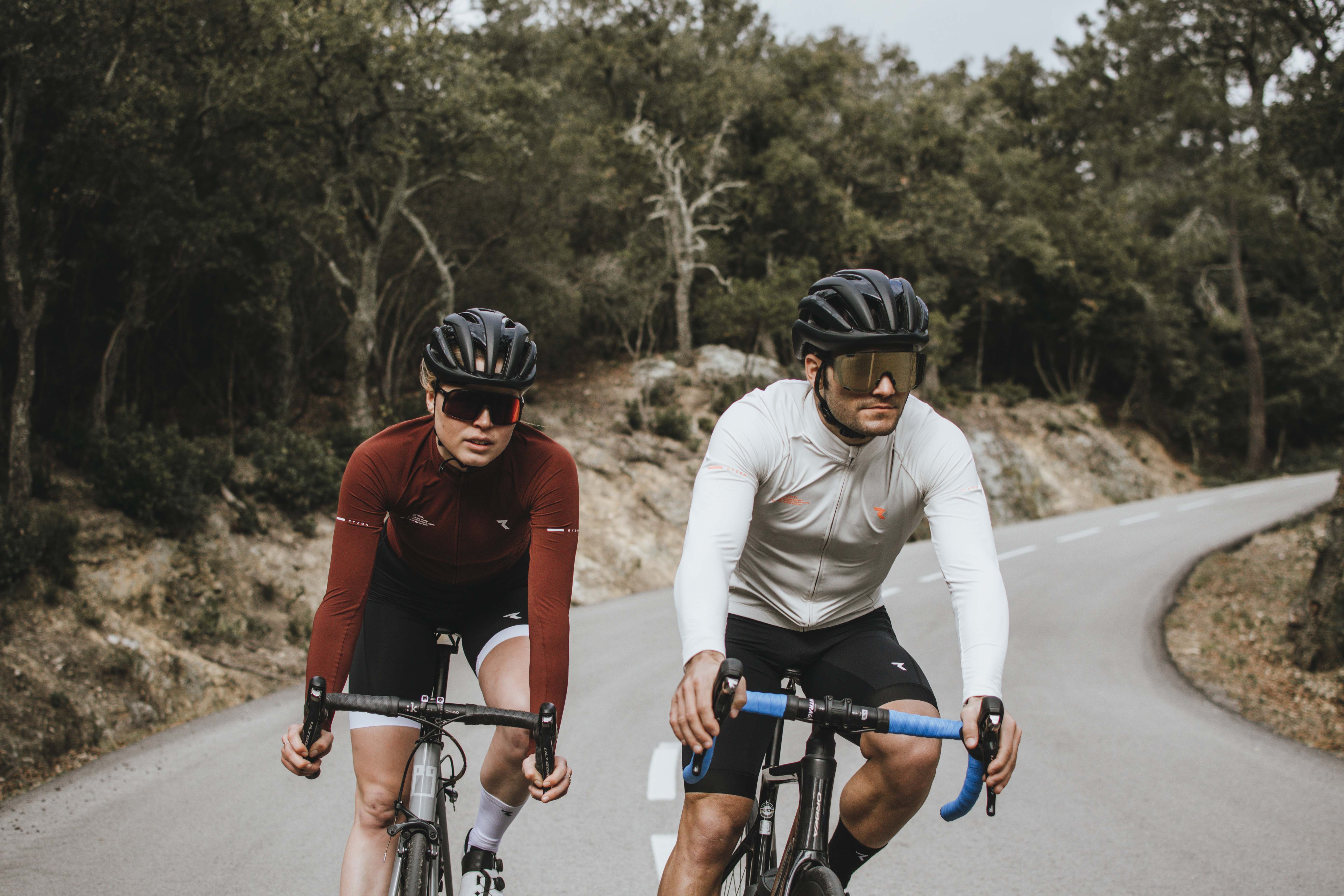 Man and woman riding racing bikes across a road
