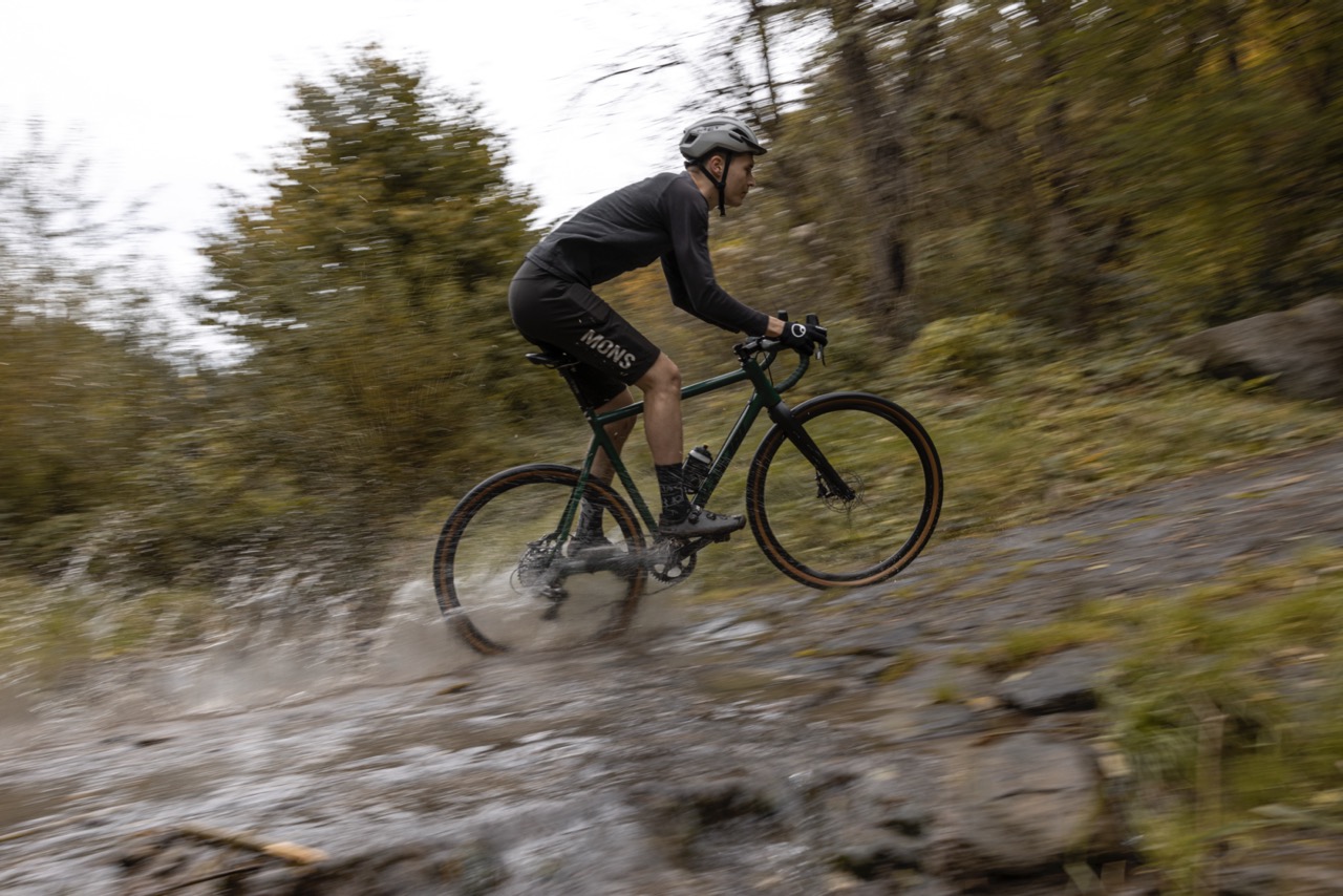 Man riding on muddy ground with a gravel bike