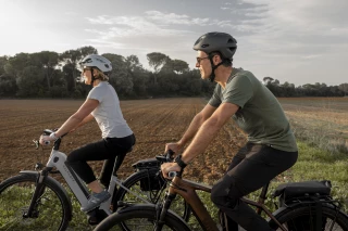 Richtige Körperhaltung Mann und Frau fahren nebeneinander Fahrrad.