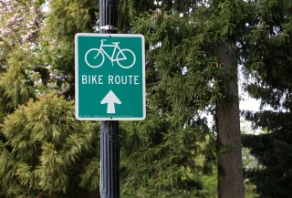Bike Route Bicycle route sign on a lamppost in a park with trees in the background