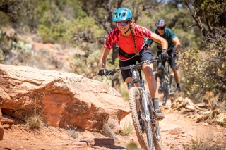 Frau Sedona MTB Frau fährt mit MTB über einen felsigen Weg. Dahinter fährt ein Mann.
