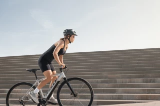 Fitnessrad Frau Woman on fitness bike, standing slightly bent on the pedals