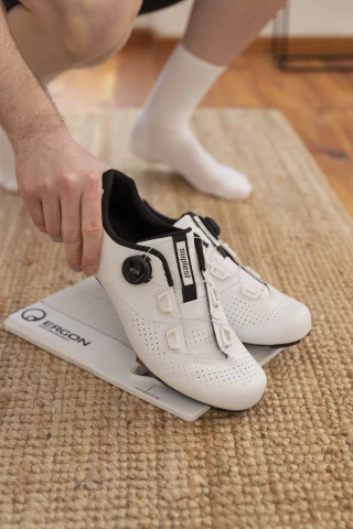 Ergon TP1 Cleat Tool – Werkzeug zur korrekten Cleat-Ausrichtung Person richtet Fahrrad-Cleats mit dem Ergon TP1 Cleat-Tool aus.