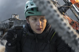 Ein Porträt von Matthew Fairbrother, wie er konzentriert und entschlossen sein Bike über den Berg trägt. Der Ergon-Sattel und die ergonomischen Griffe begleiten ihn bei jedem Schritt.