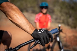 Szenenausschnitt von zwei Mountainbikern auf einer Wüstentour mit Fokus auf Ergon HM2 Handschuhen. 