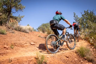 MTB woman man Woman and man riding their mountain bikes through terrain