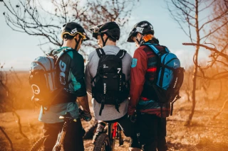 MTB 3 riders 3 MTB riders standing together, all of them wear backpacks