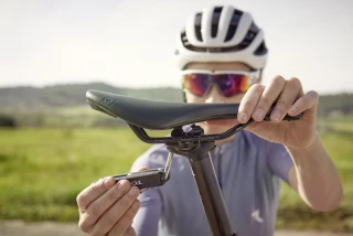 Ergon Sattelposition anpassen Radfahrer justiert die Sattelhöhe an seinem Ergon Sattel für optimale Fahrposition.
